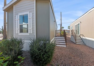 Model home exterior with shrubs at Desert Valley Oasis Manufactured Homes in Mesa Arizona